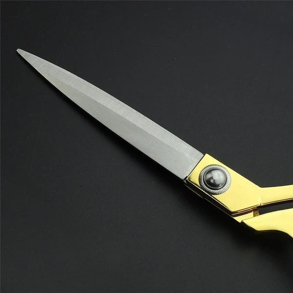 Elegant golden tailoring scissors resting gently on a textured fabric swatch, ready for use.