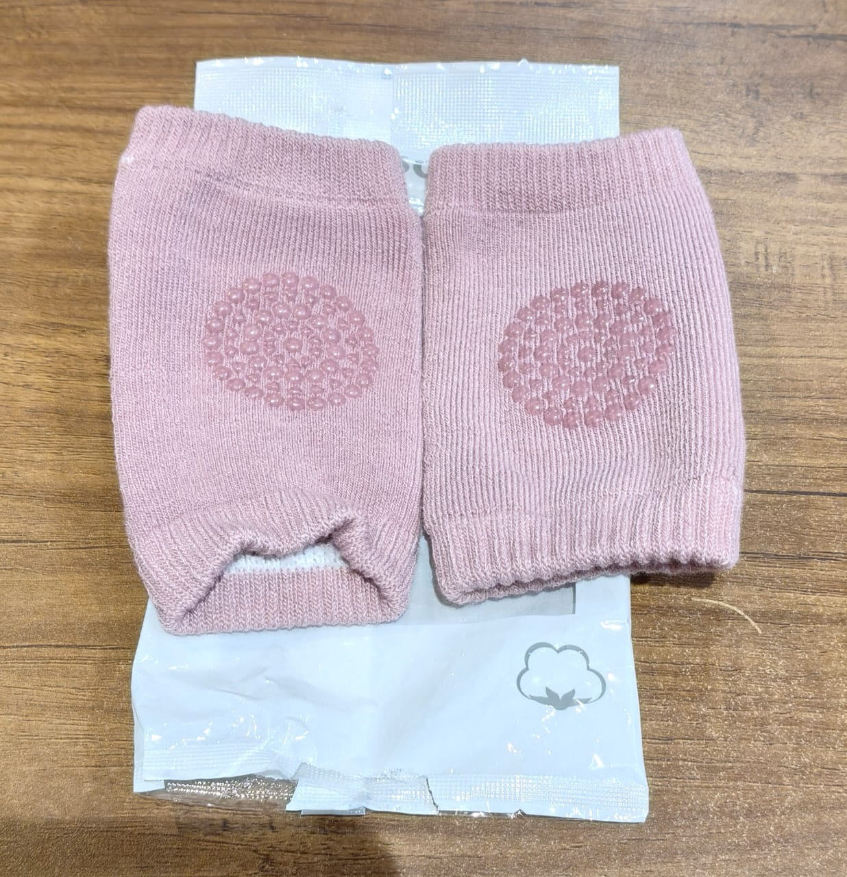 Close-up of knitted pink wool toddler knee warmers with protection