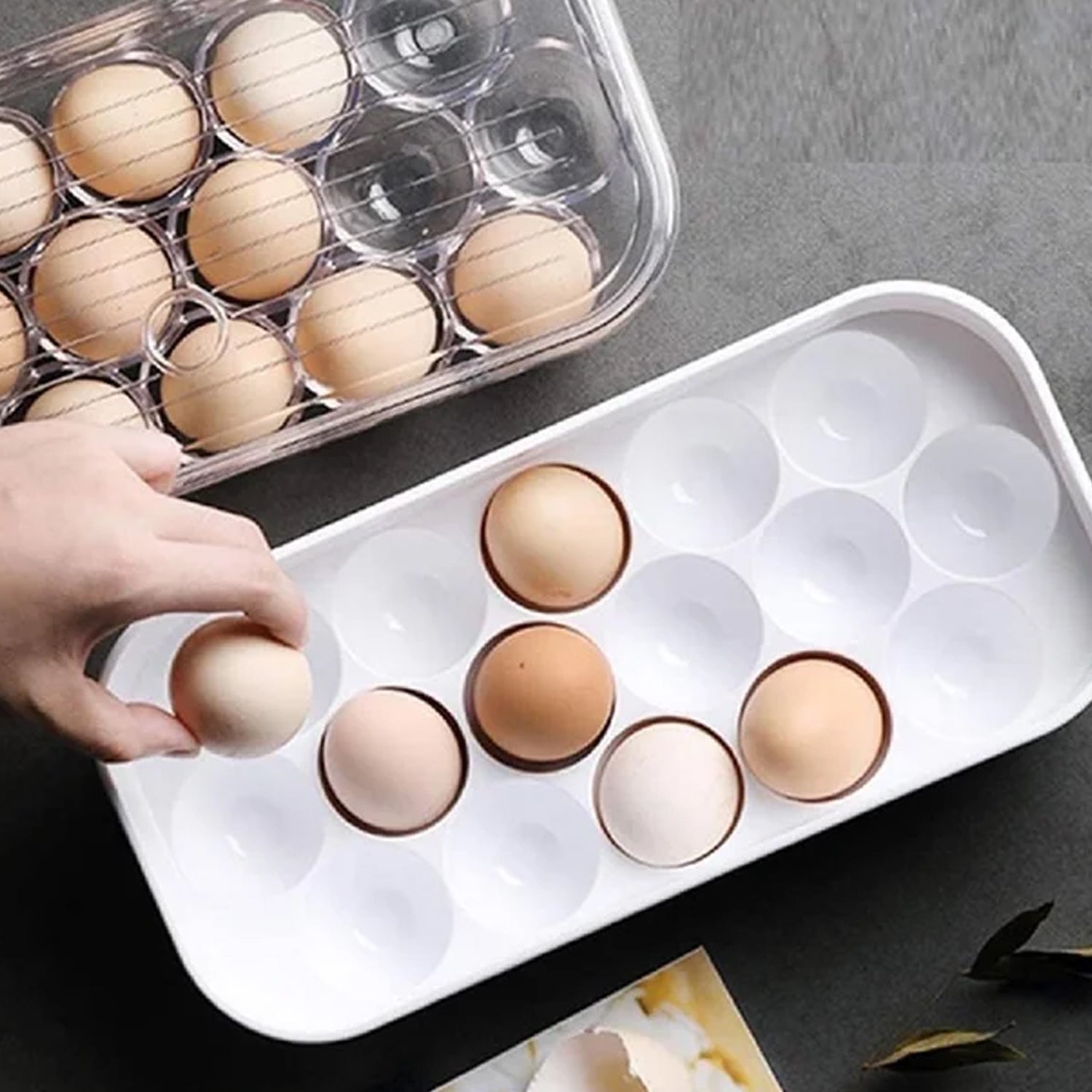 Clear plastic 12-cavity egg storage box with a lid, holding white eggs.