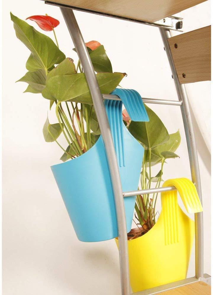 Assorted plastic hanging planter pots in a garden setting.