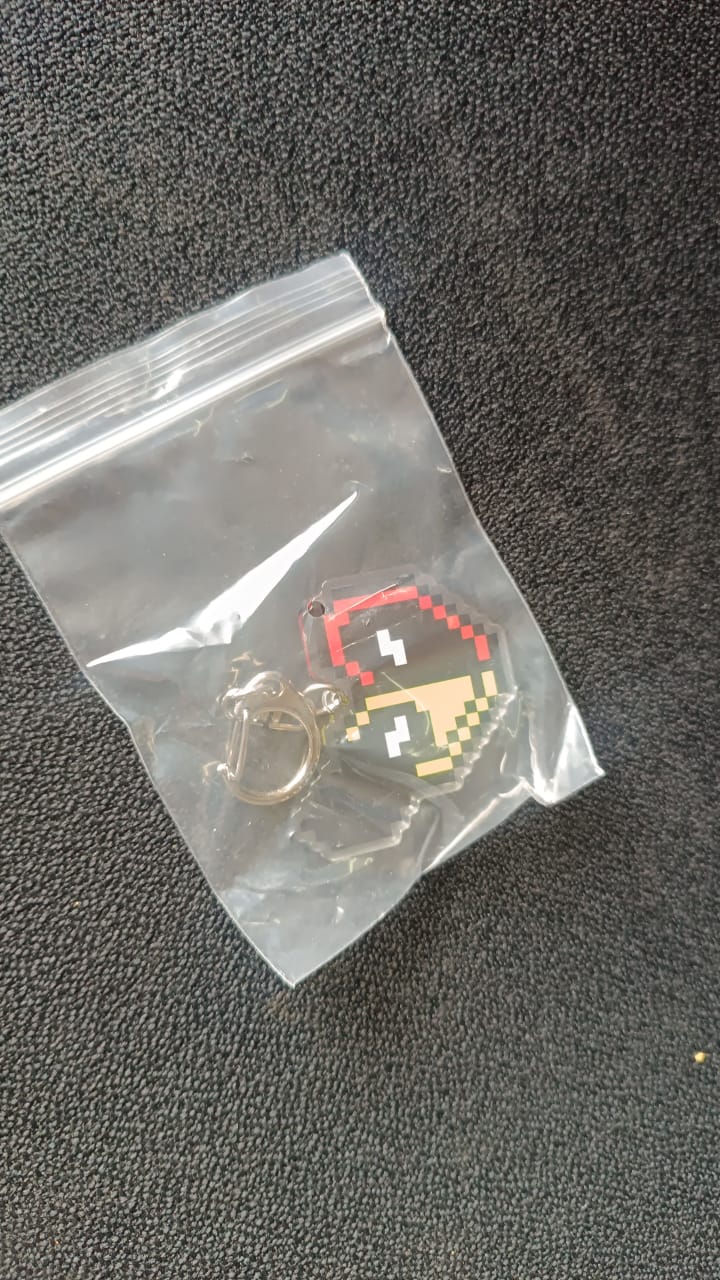 Pixel style acrylic keychain displayed on black background showcasing retro heart