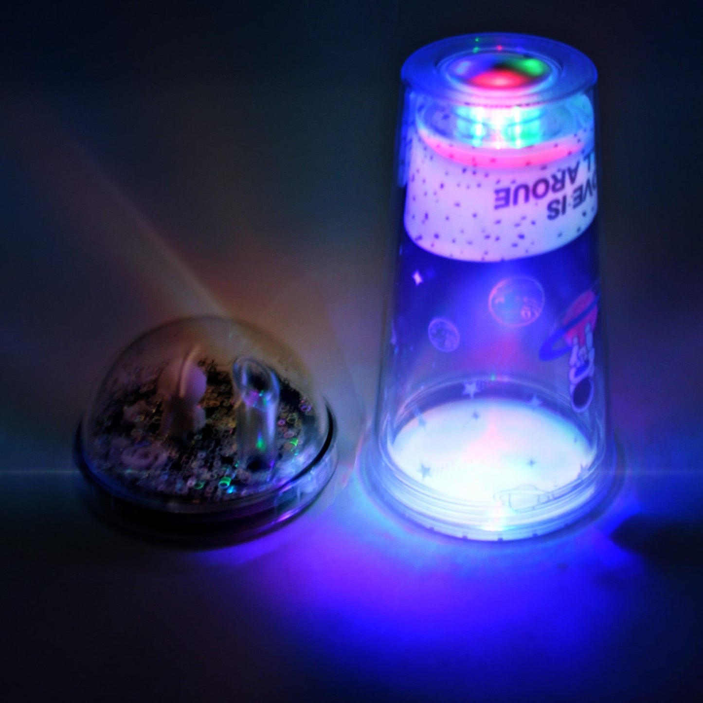 An astronaut tumbler with a straw and glowing LED base, ready for school or outdoor activities.