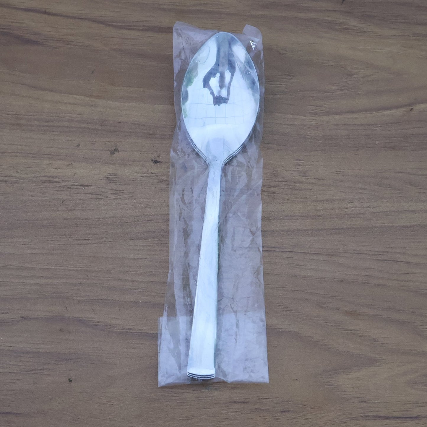Stacked stainless steel dining spoons placed in a home kitchen setting