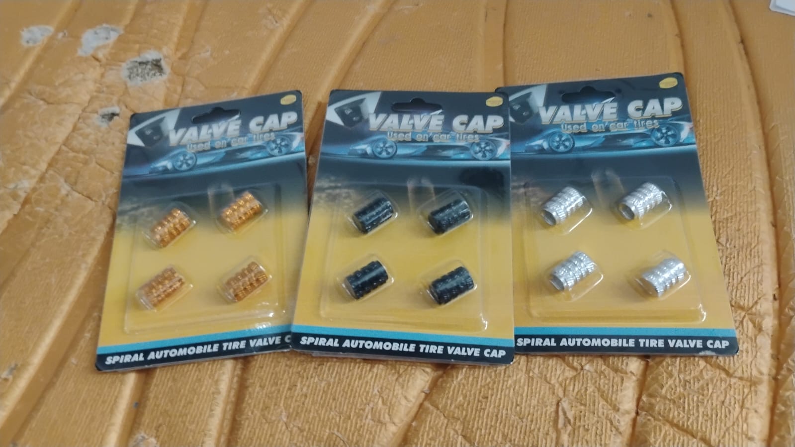 Silver aluminium valve stem cap resting on smooth surface