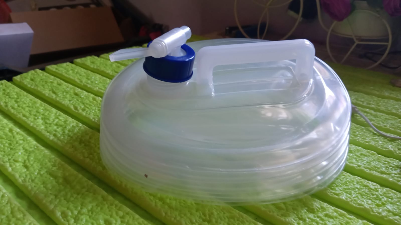 10L Collapsible Water Container in use at an outdoor camping site.