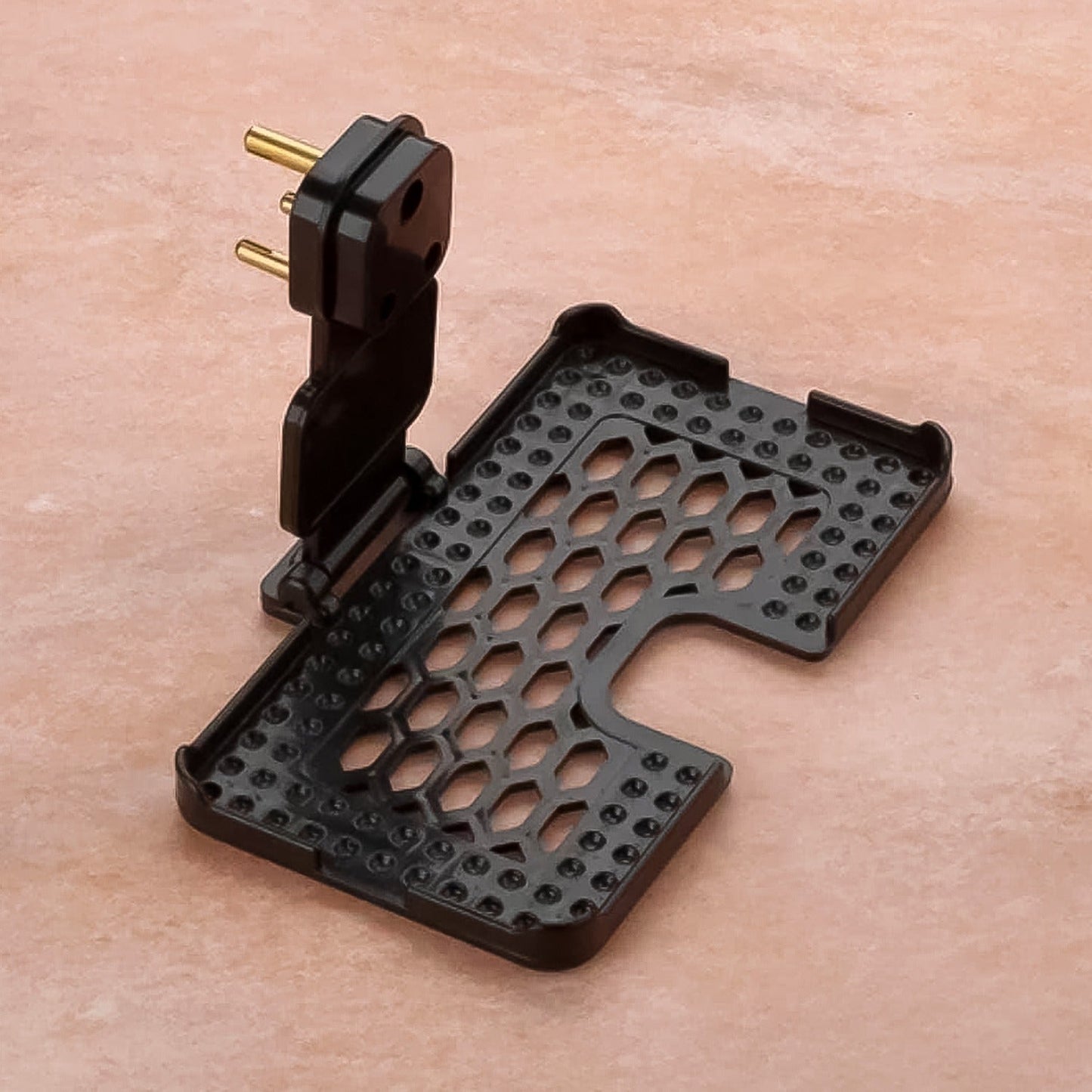 Close-up of the Mobile Charging Holder's open slots for ventilation and stable three-pin support.
