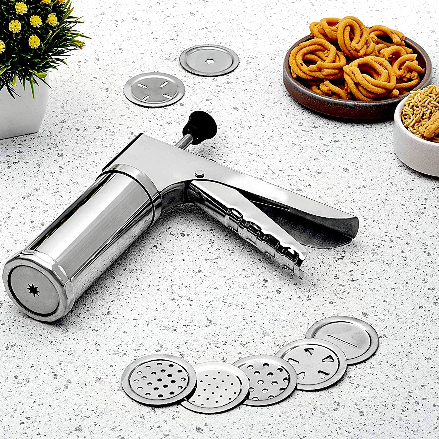 Stainless steel kitchen press with 15 interchangeable discs for making various Indian snacks.