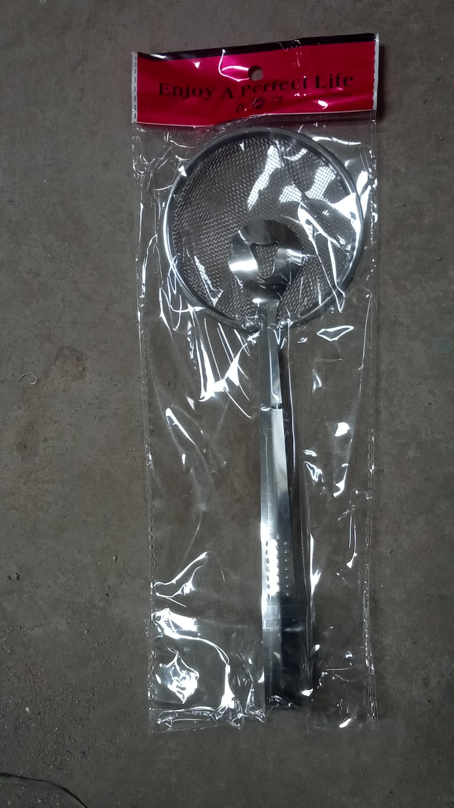 Frying filter spoon with clip used in a modern kitchen setting.