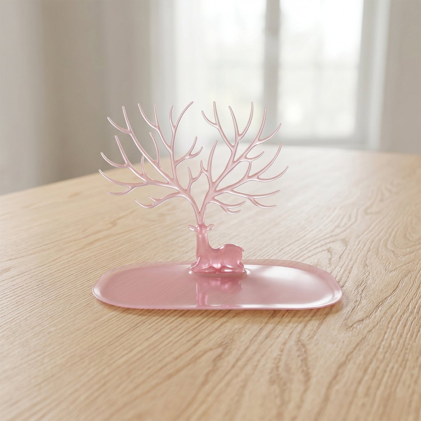 Base view of pink deer jewelry stand on table, India