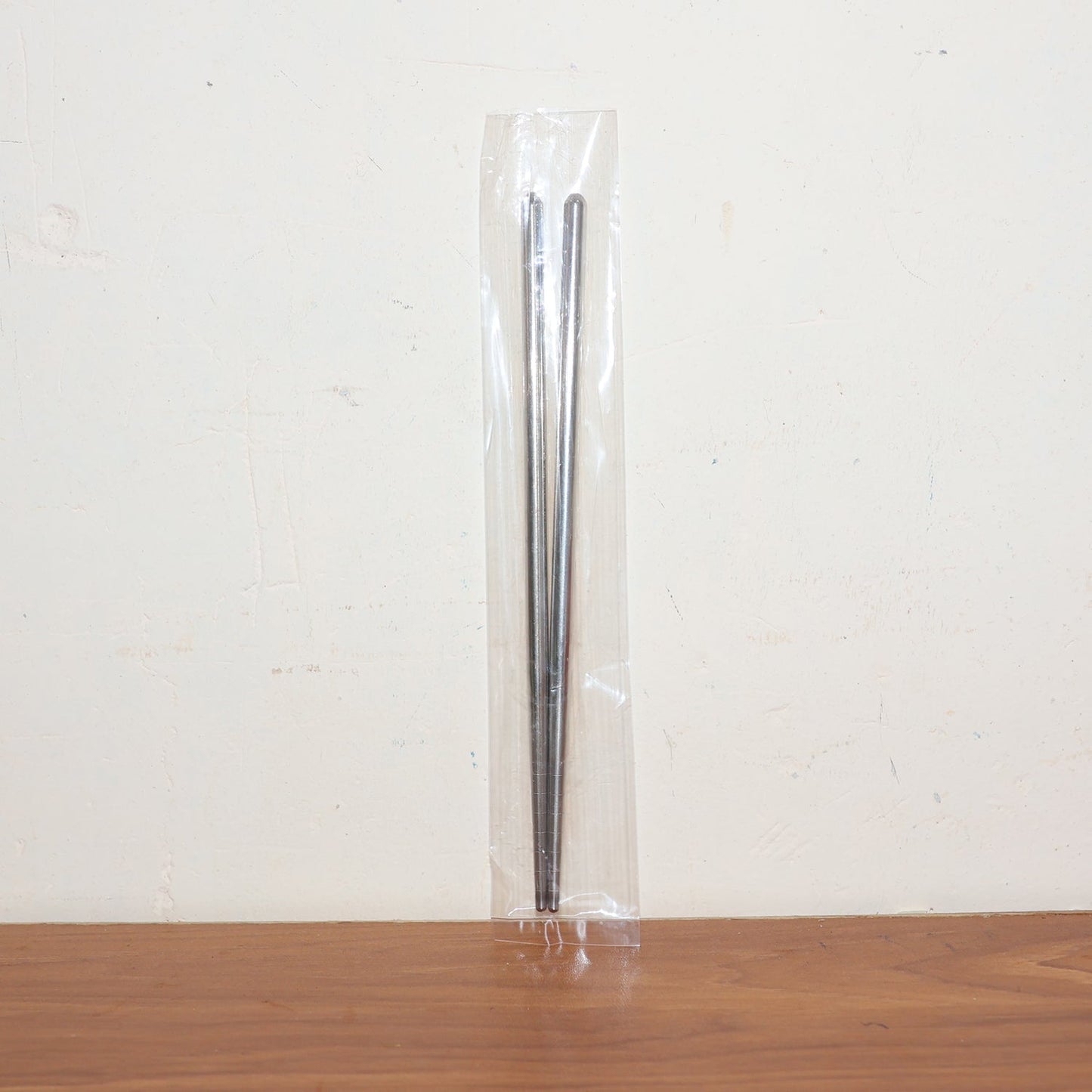 Stainless steel chopsticks actively used to pick up food during a meal.