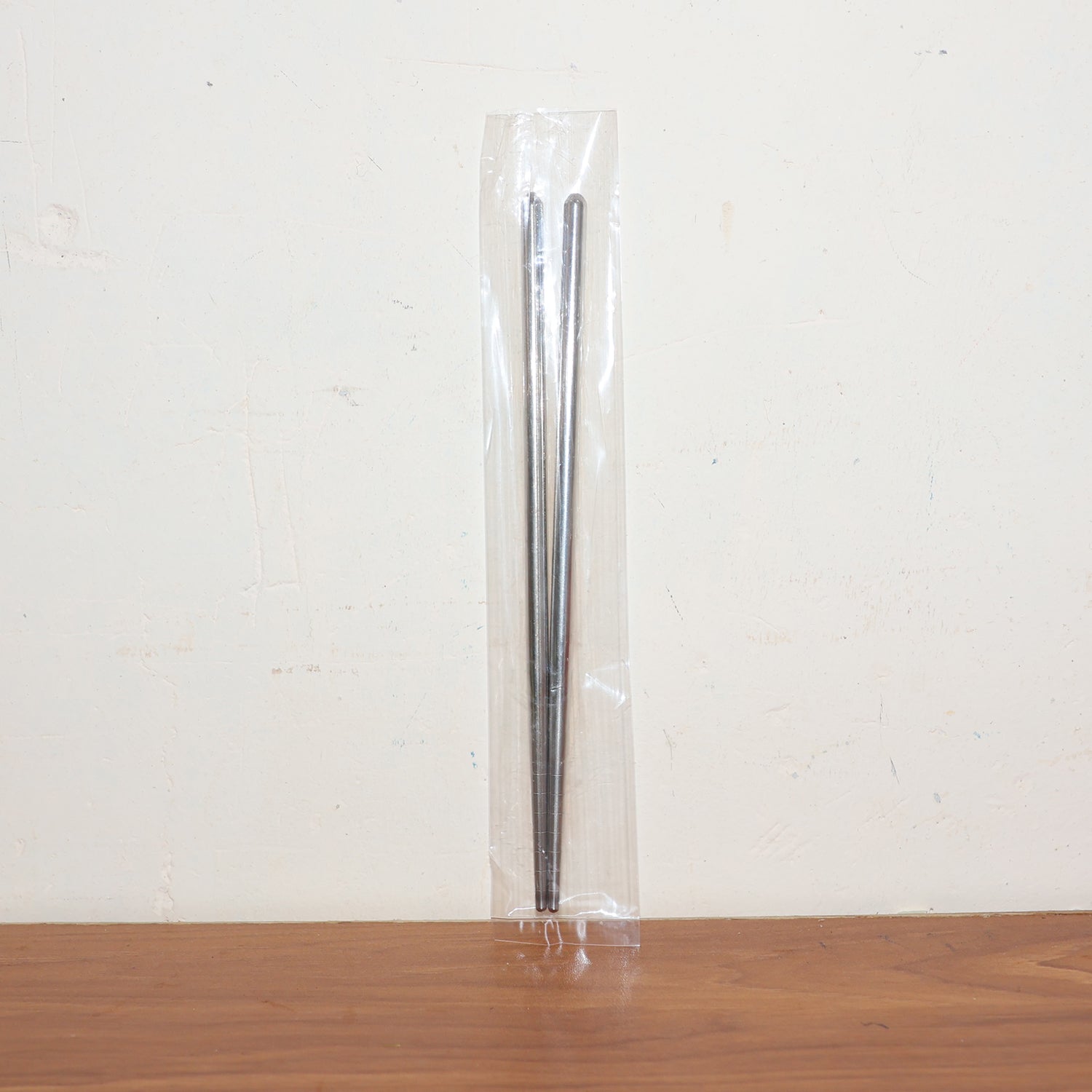 Stainless steel chopsticks actively used to pick up food during a meal.