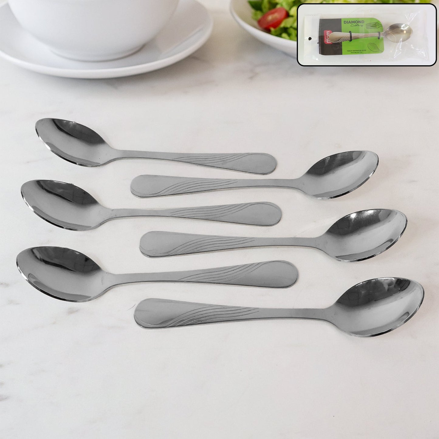 Set of six polished stainless steel dining spoons with elegant engraved handles