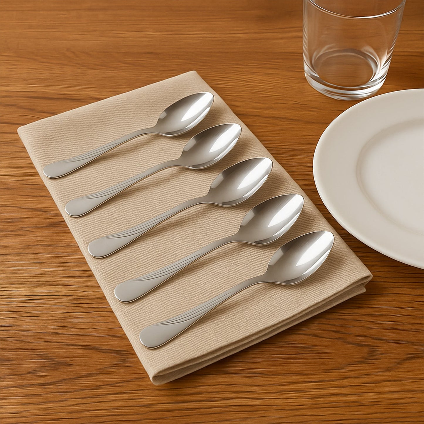 Close-up of elegant stainless steel dining spoons with engraved handles