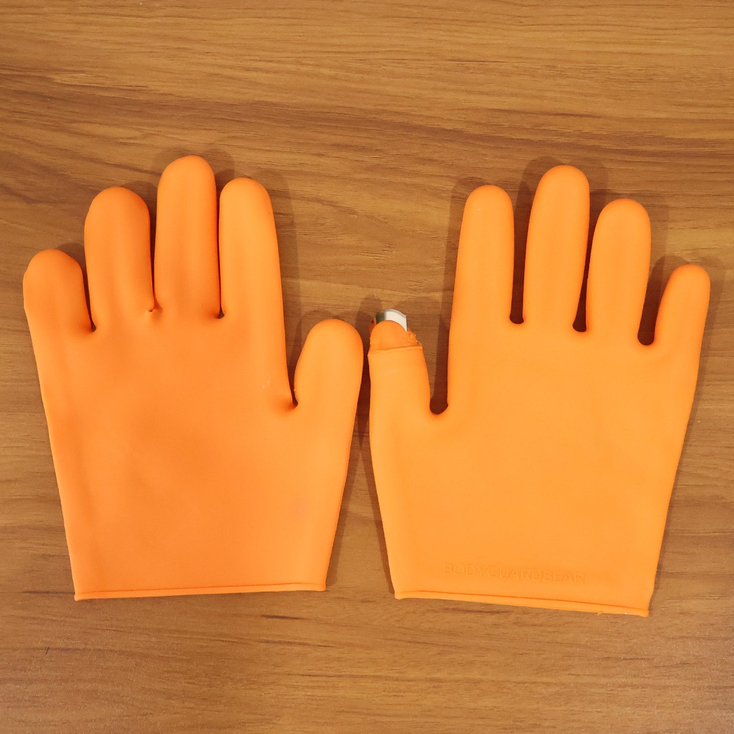 Full view of orange silicone gloves with finger protector