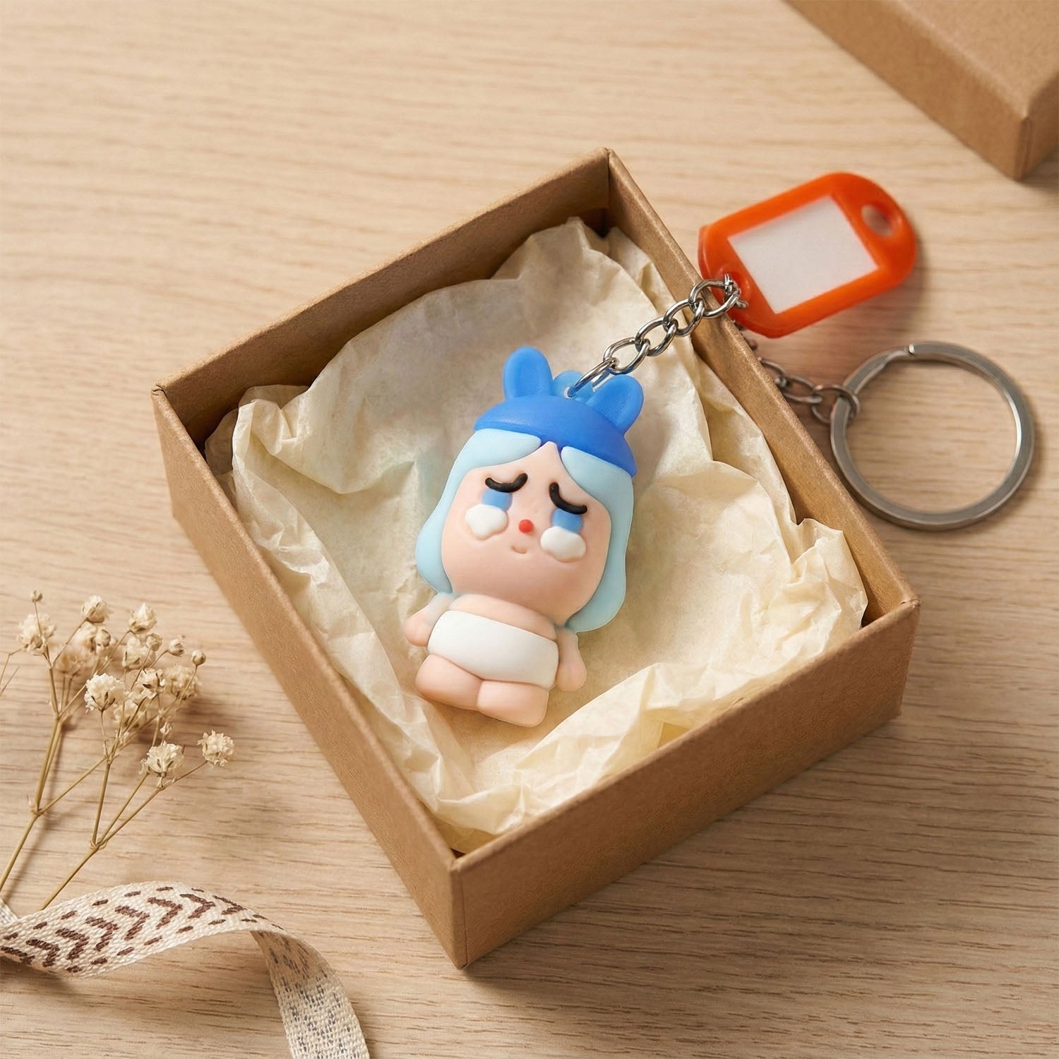 Cartoon keychain accessory showing baby character with metal key ring.