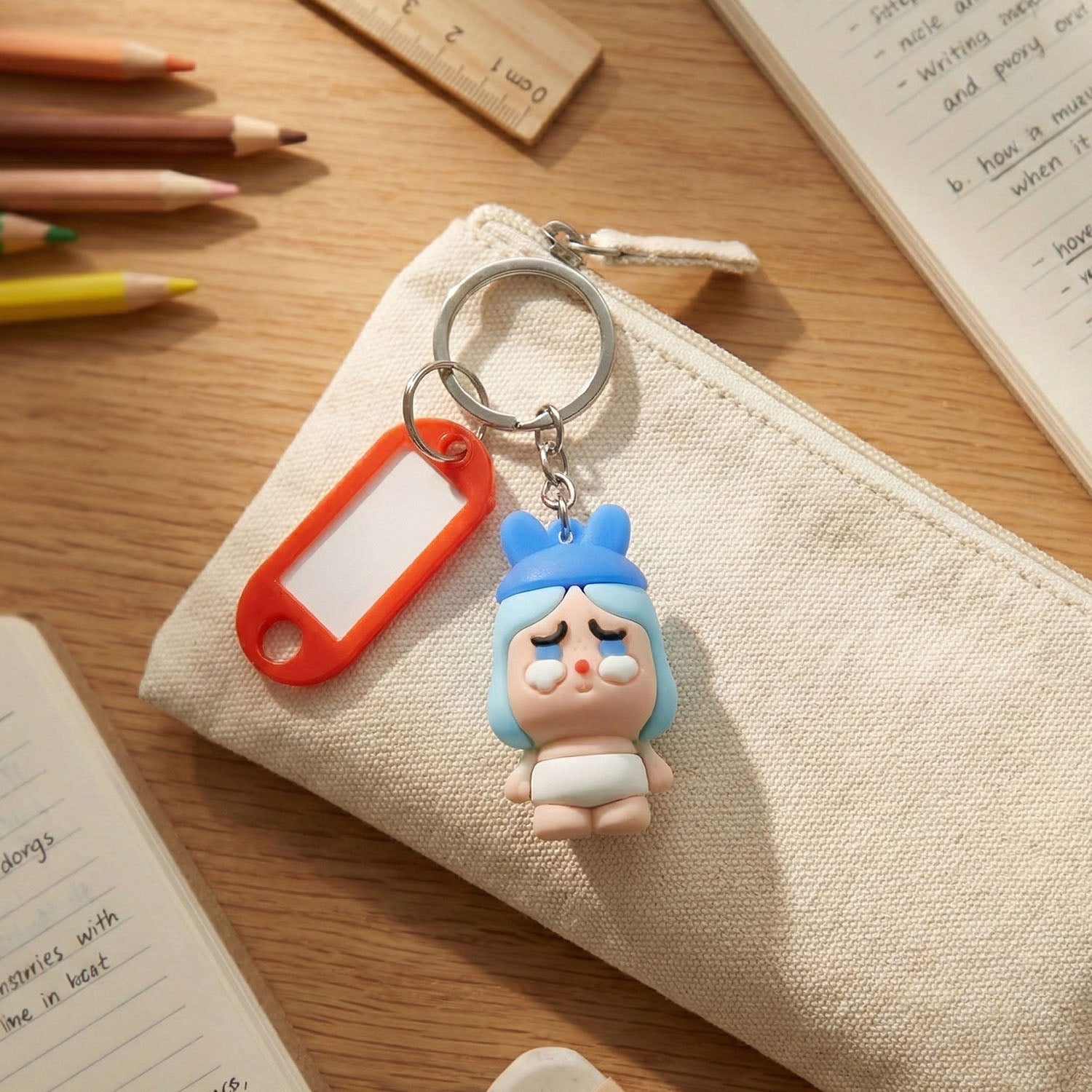 Cute figure keychain featuring a baby cartoon with a label for identification.