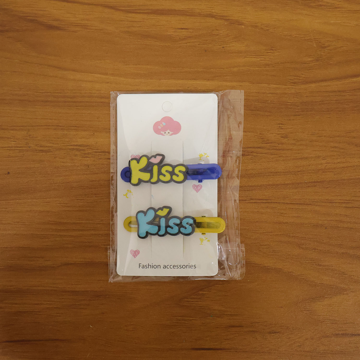 Model wearing Kiss cartoon letter snap hair clips as playful accessory