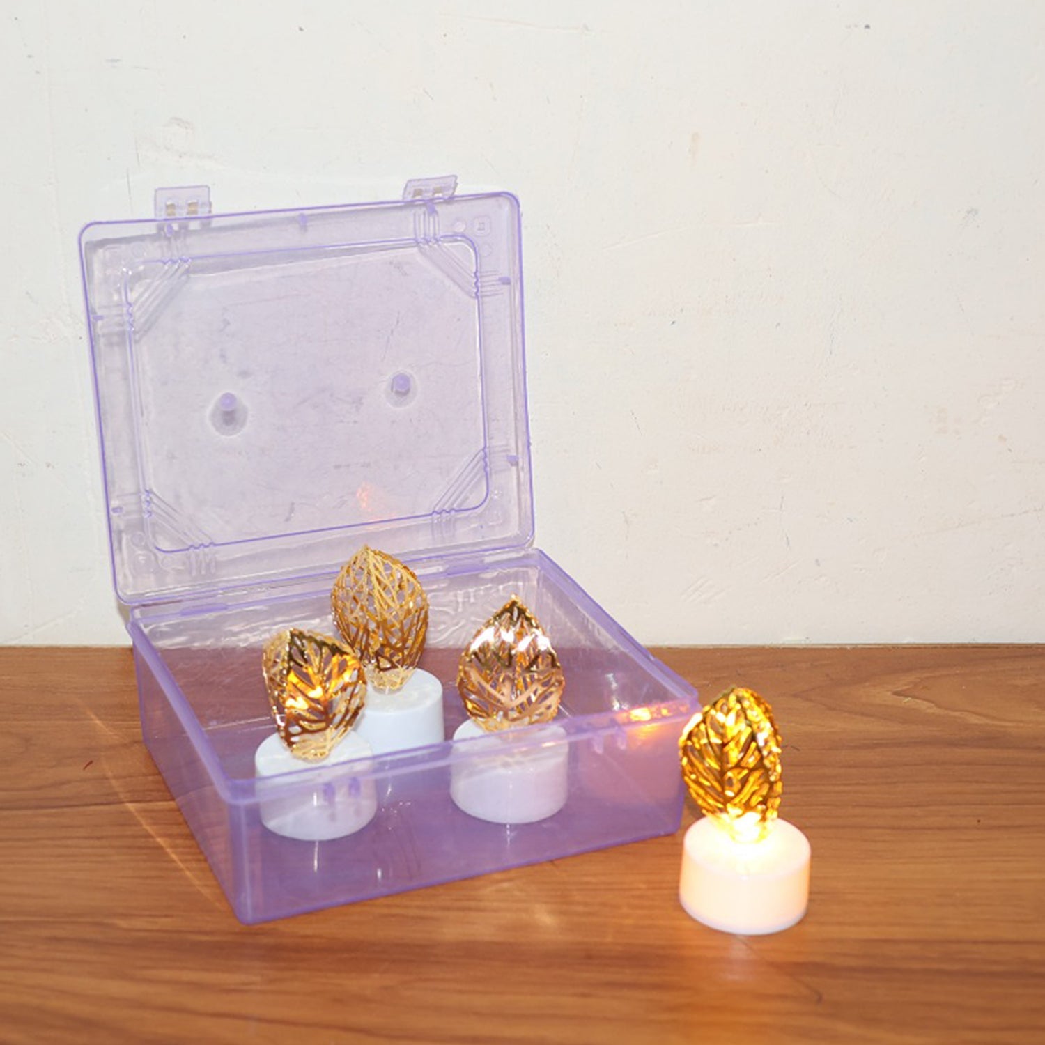 Overhead shot of multiple golden leaf LED candles in a warm, inviting display.