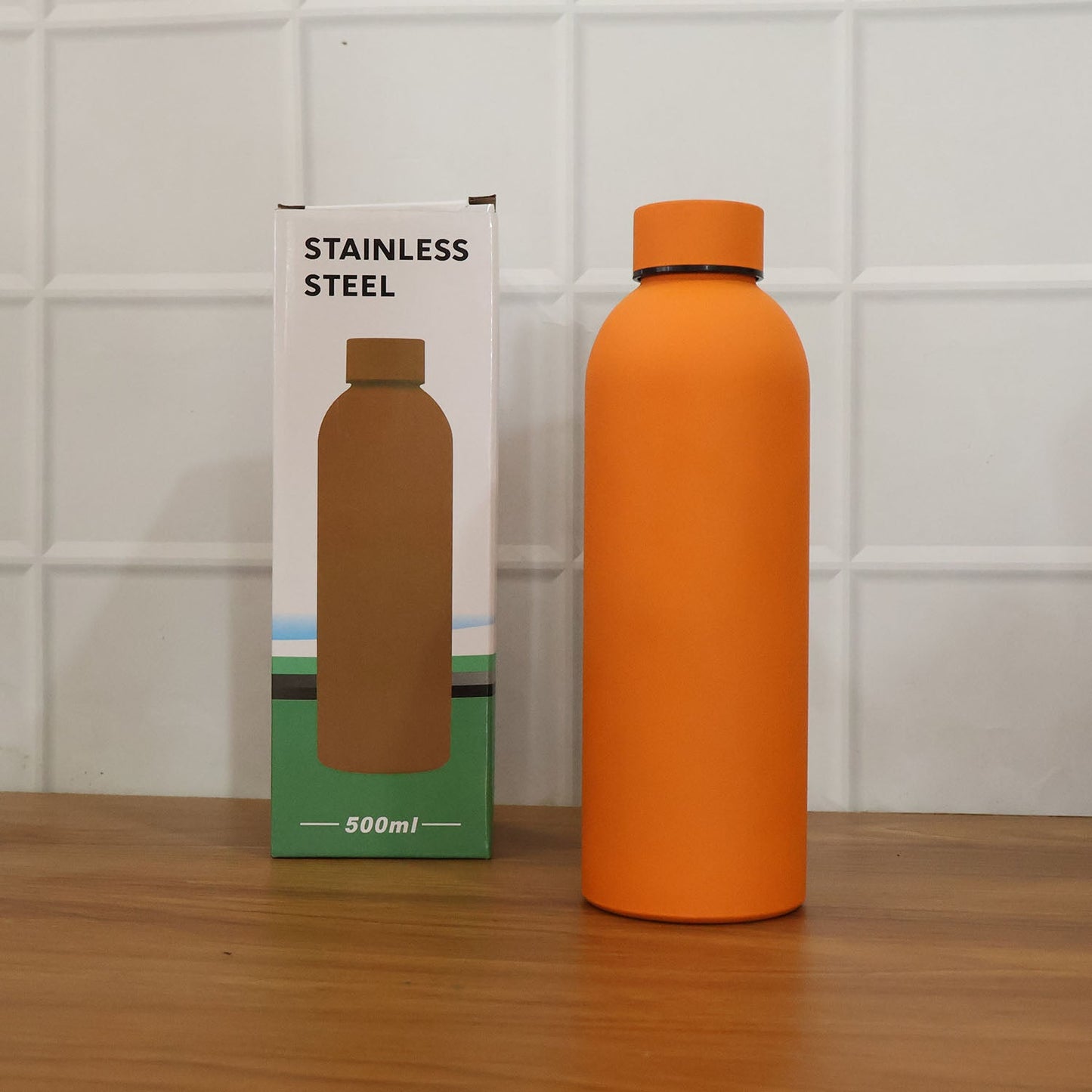 Lifestyle image featuring stainless steel insulated orange water bottle