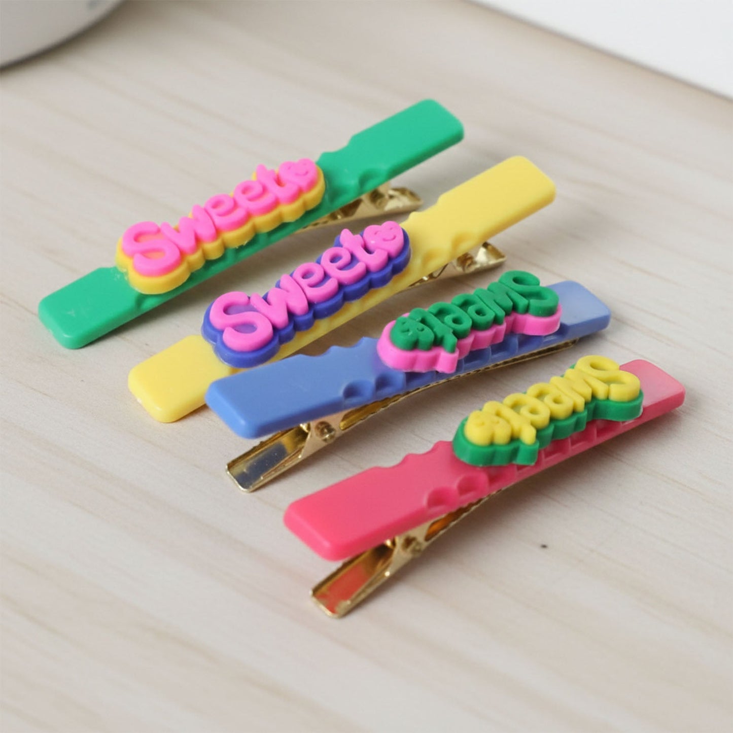 Sweet Text hair clips shown on a neutral background