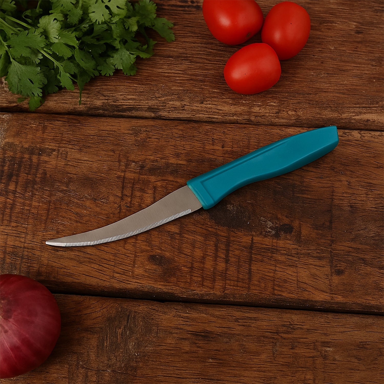 Close-up of stainless steel tomato knife featuring curved serrated blade