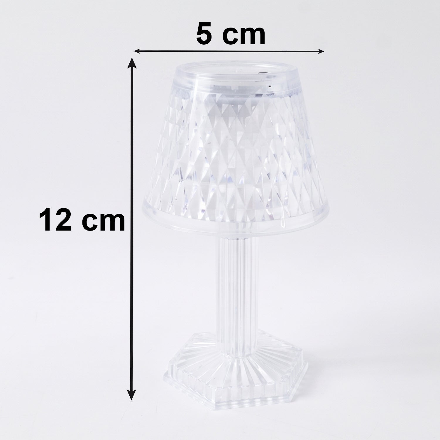 Small crystal table lamp creating a warm, ambient glow in a dark room.