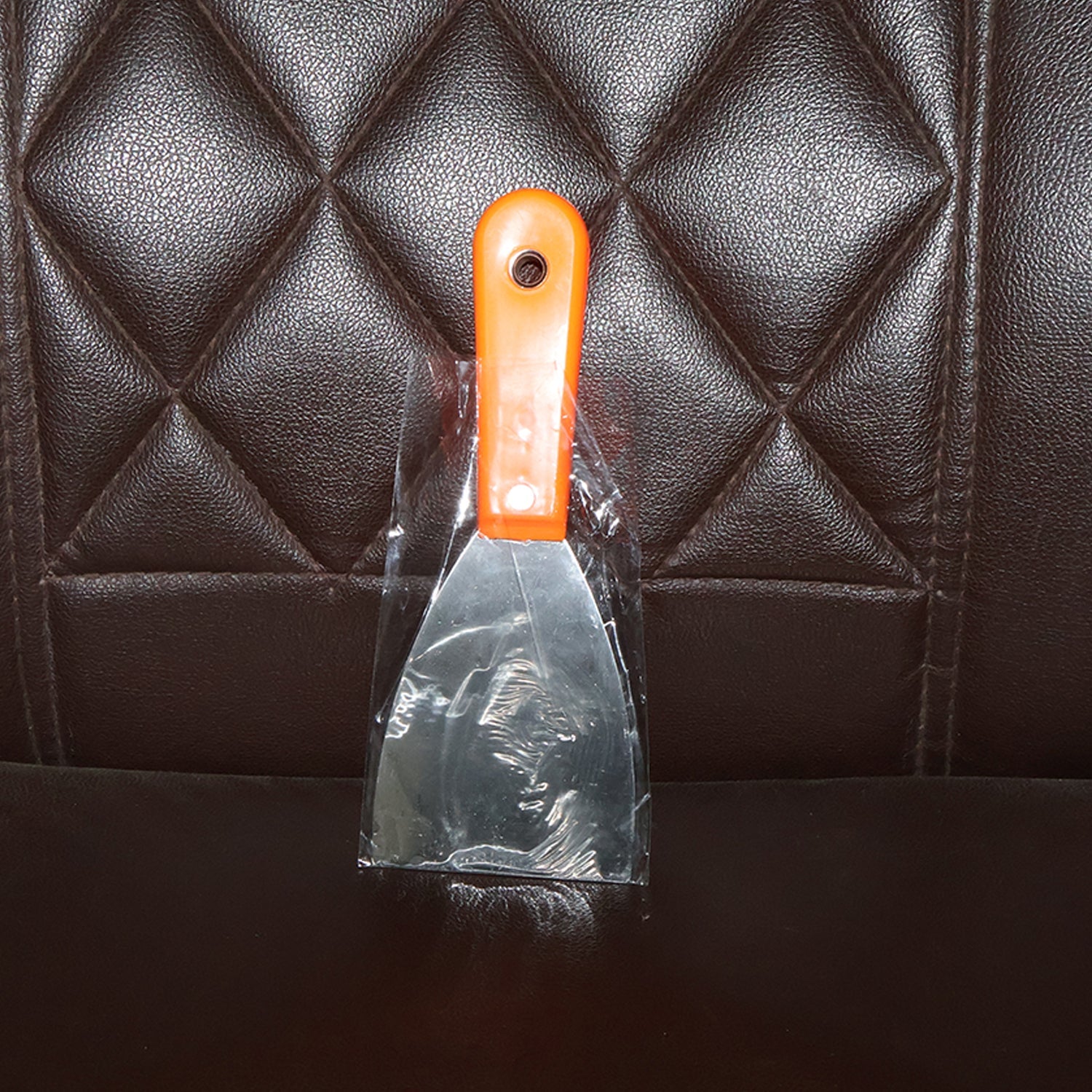 Putty knife with a comfortable soft rubber handle and a hanging hole for easy storage.