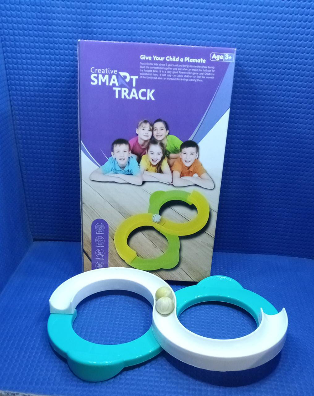 A child happily demonstrating a built track from the marble run toy set.