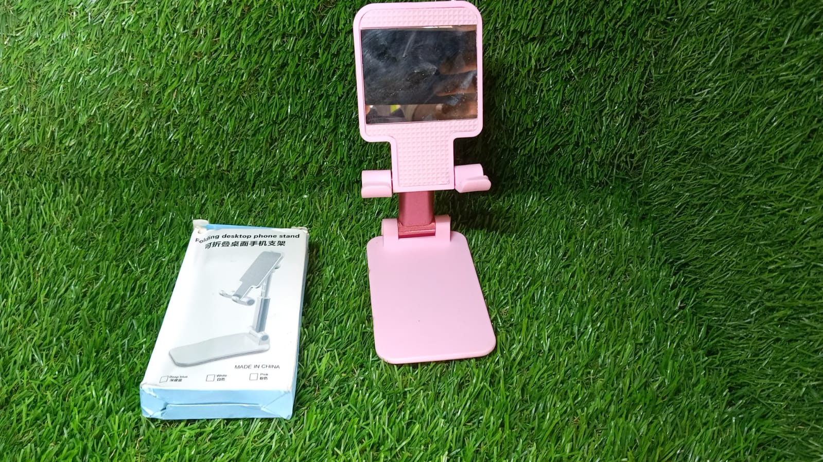 Lifestyle shot of the adjustable phone stand with mirror, holding a smartphone.