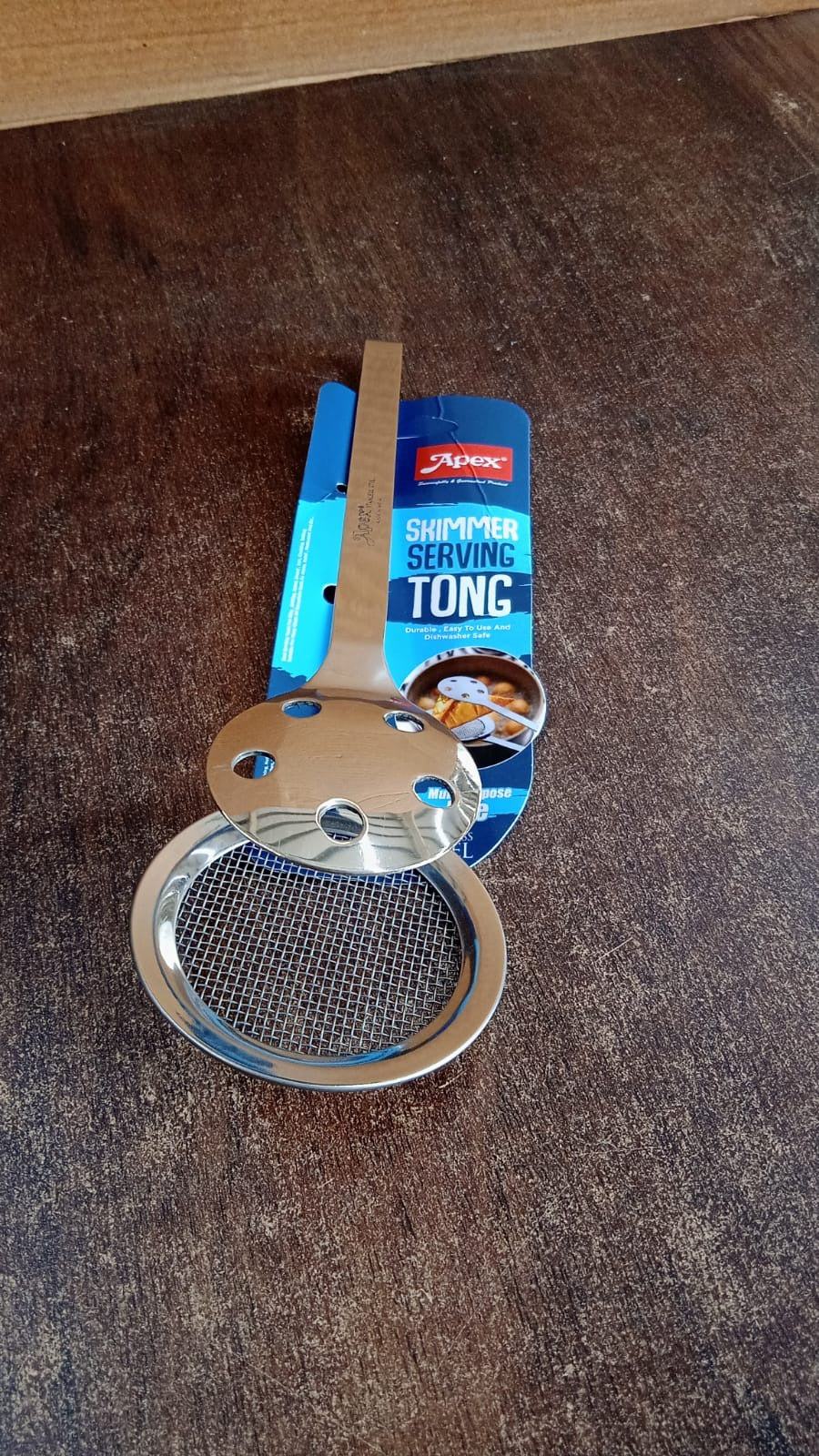 Stainless steel skimmer serving tong by Apex in use with fried snacks