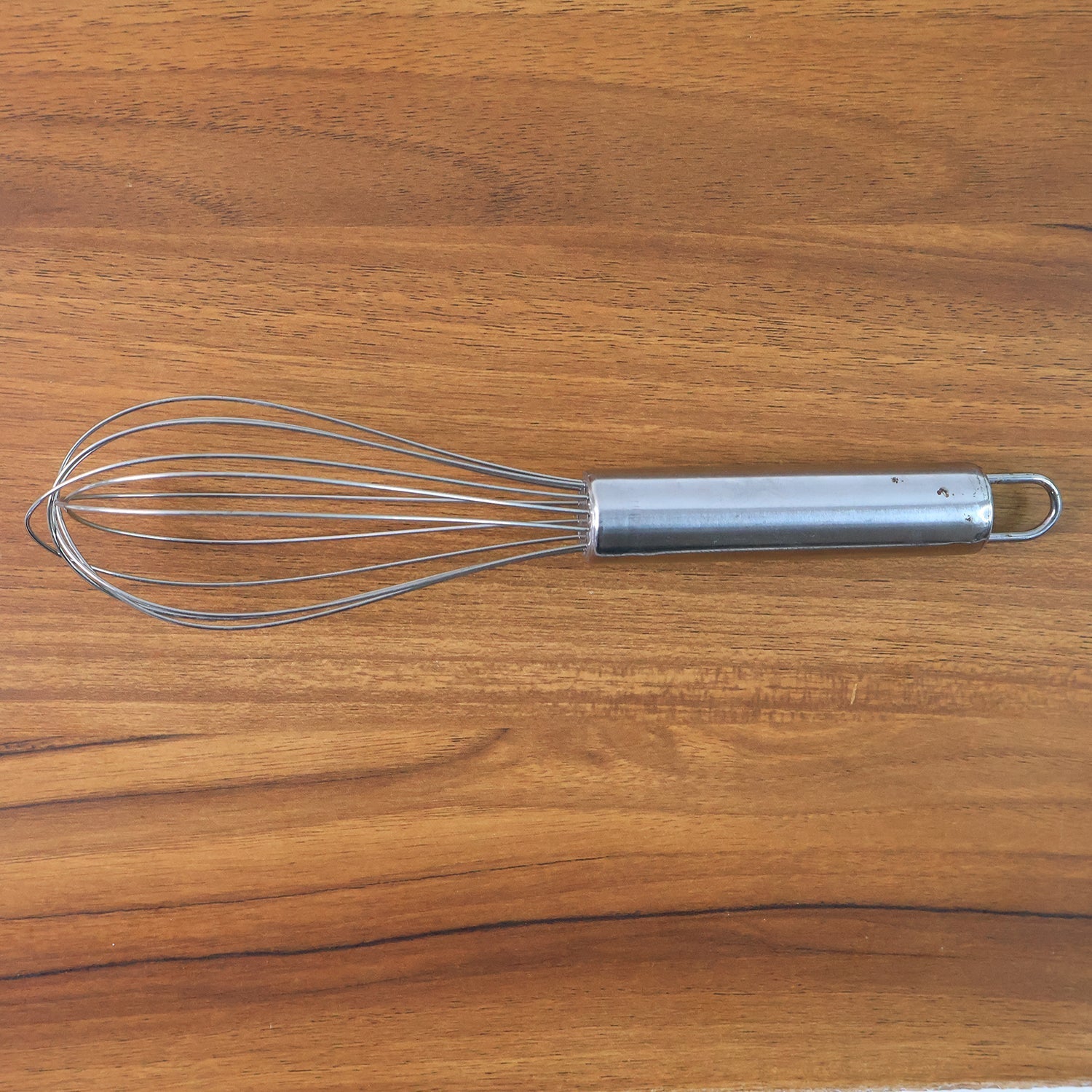 Small stainless steel balloon whisk on white background