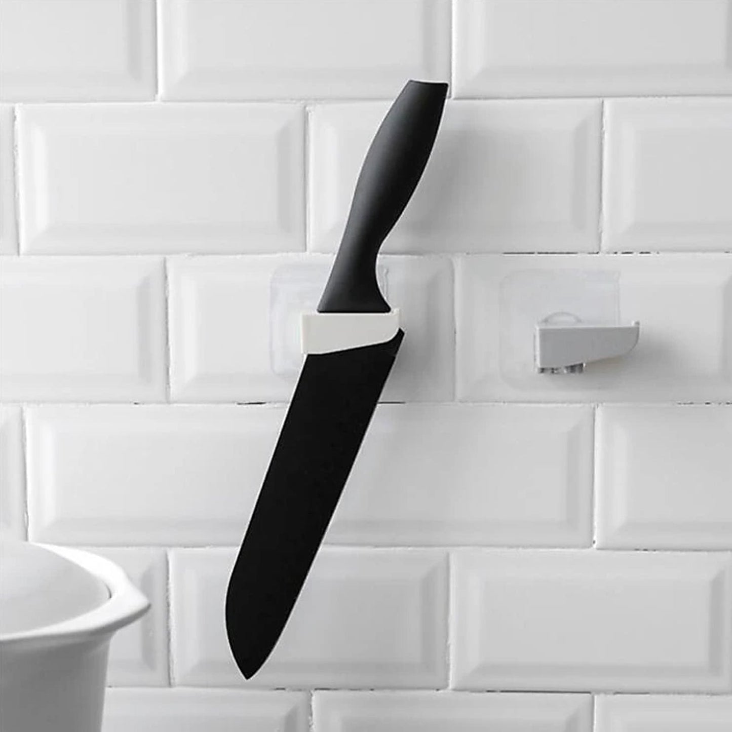 A sleek black punch-free wall hanging knife holder mounted on a kitchen wall, showcasing its modern design and space-saving functionality.