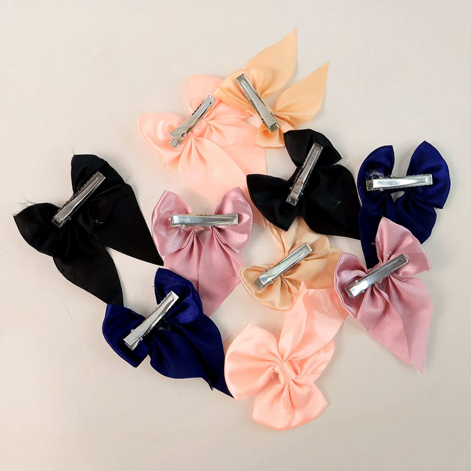 Collection of satin bow hair clips arranged neatly