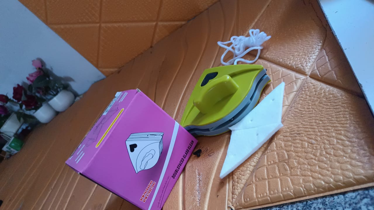 Woman effortlessly cleaning a window with the magnetic double-sided glass cleaner.