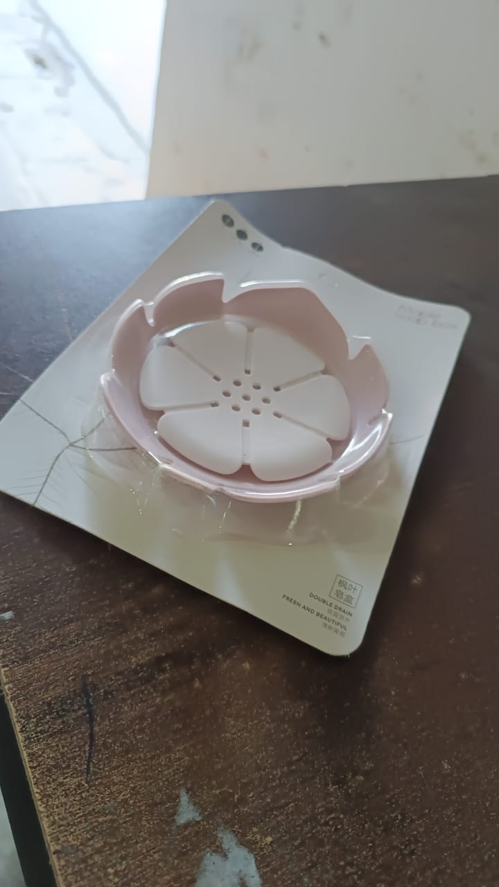 The white plastic soap dish displayed on a simple background.