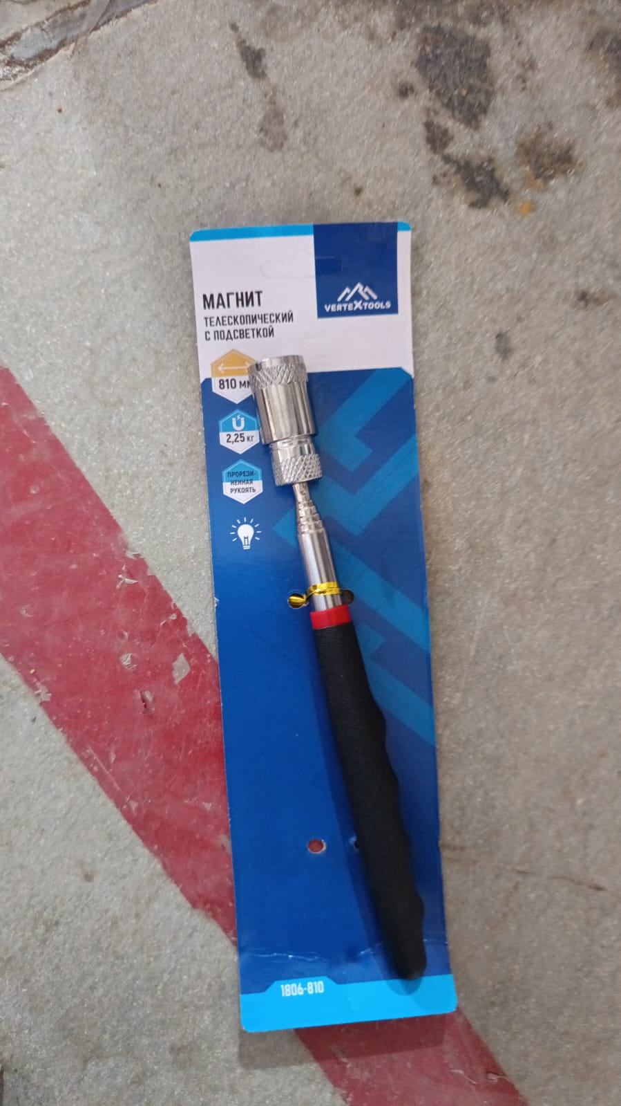 Hand holding the compact magnetic pick up tool.