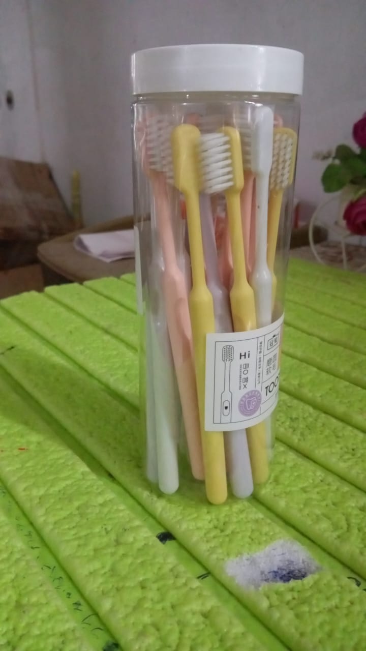 The complete 20-piece soft plastic toothbrush set with its clear portable round storage box.