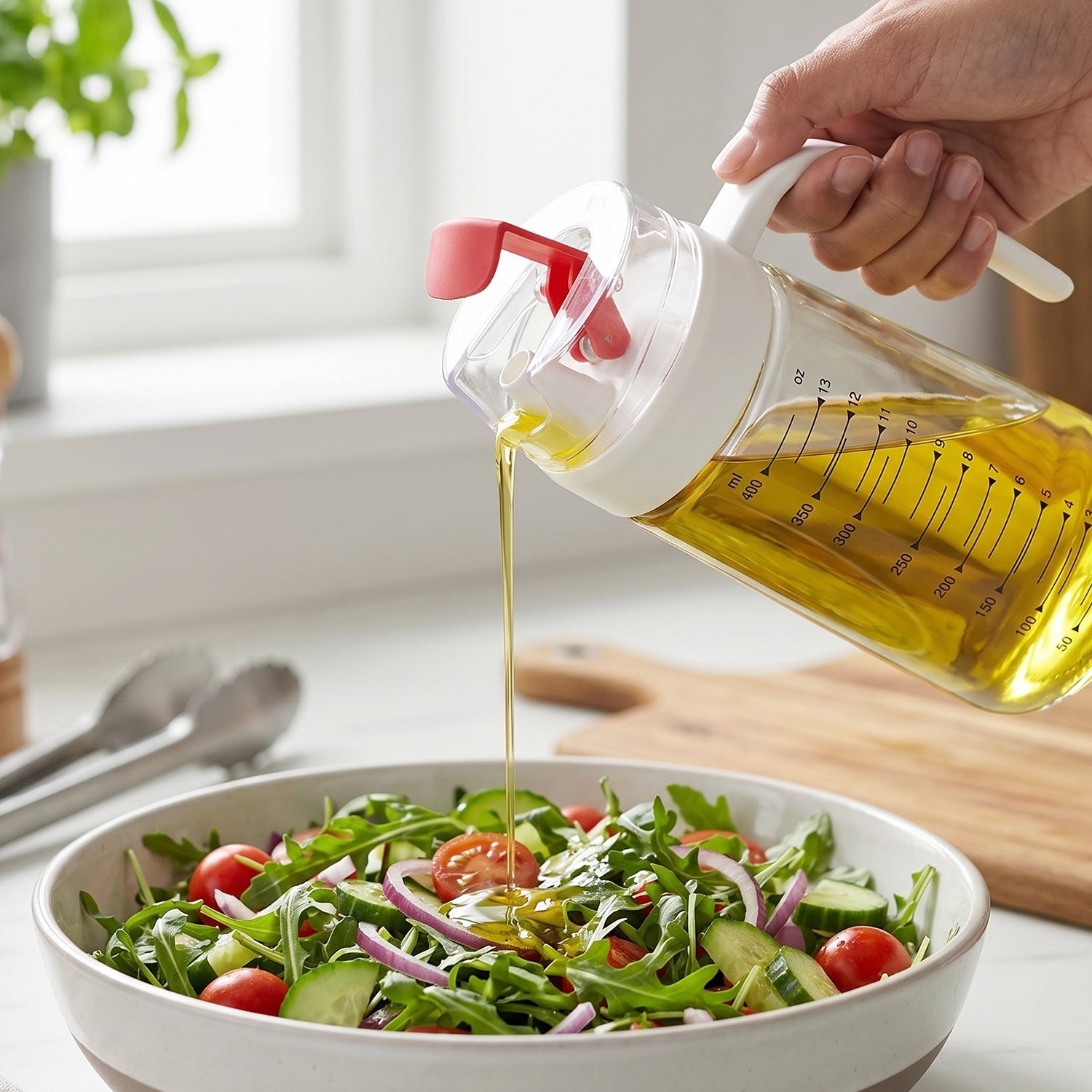 Olive oil being drizzled from glass dispenser onto a fresh salad