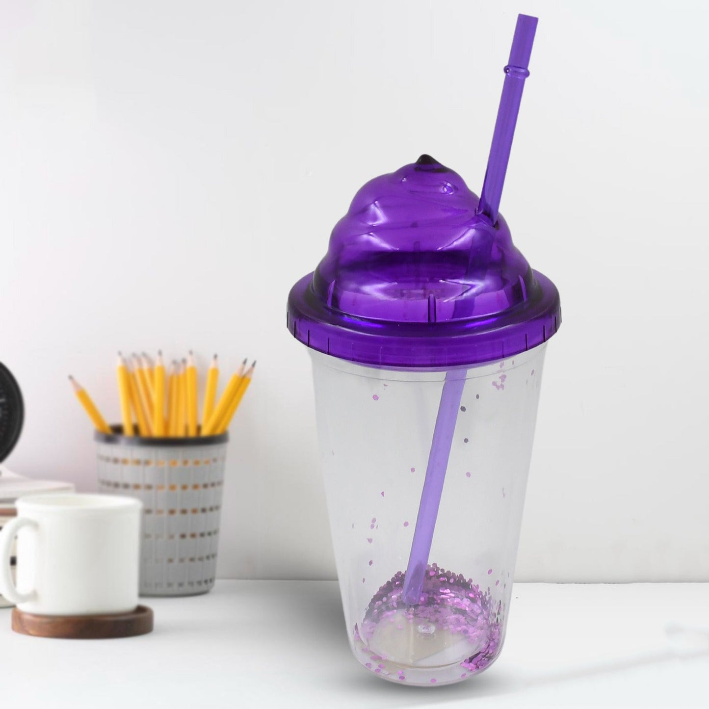 Vibrant plastic cold drink tumbler with lid and reusable straw, showcasing mixed colors.
