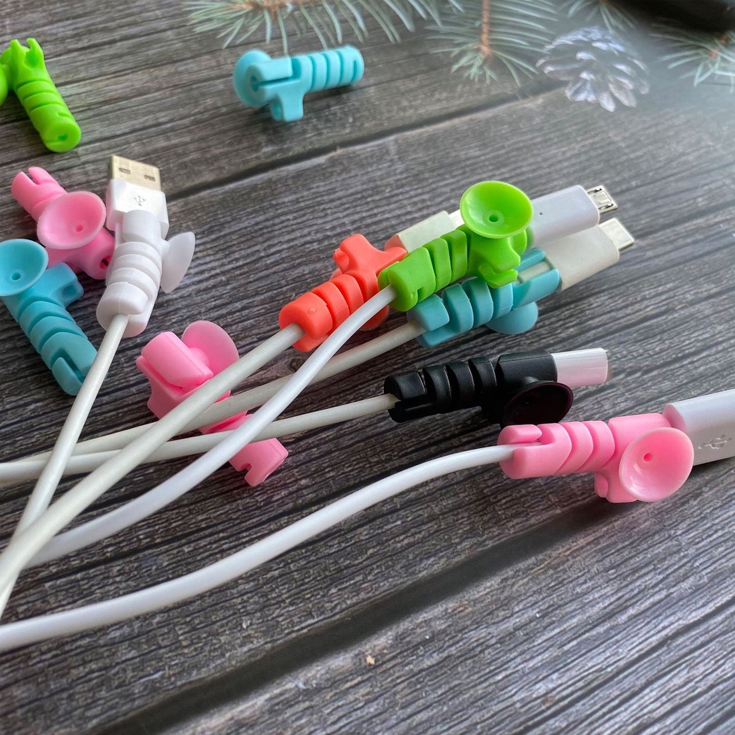 Set of four cable protectors in white, displaying their flexible design and suction ends.