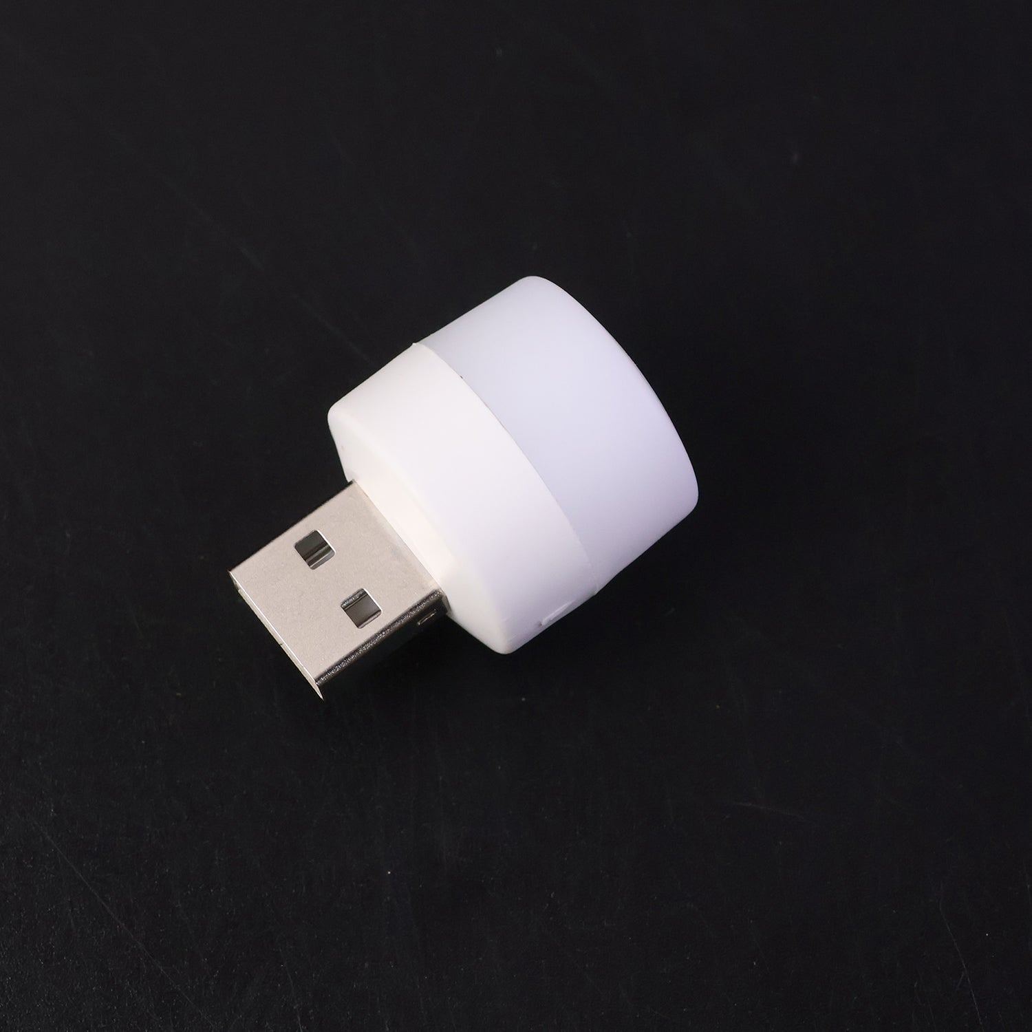 Mini portable yellow USB LED night light glowing beside a laptop keyboard